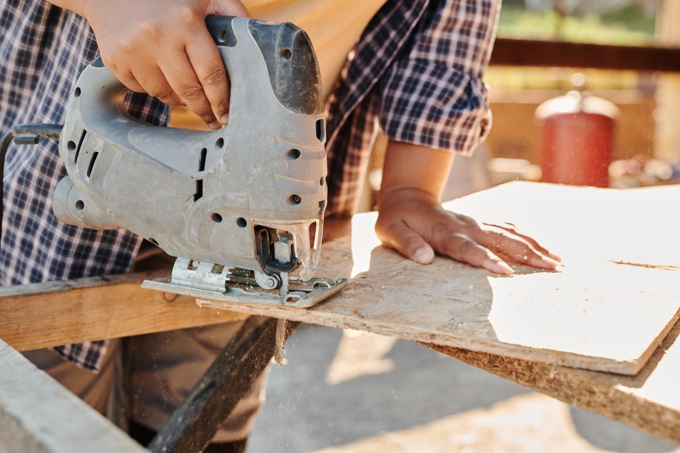 Tradesperson cutting timber on site with a jigsaw