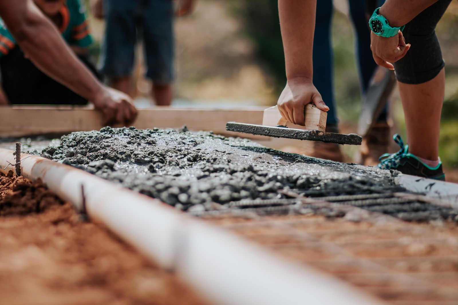 Groundworkers laying concrete on a construction site